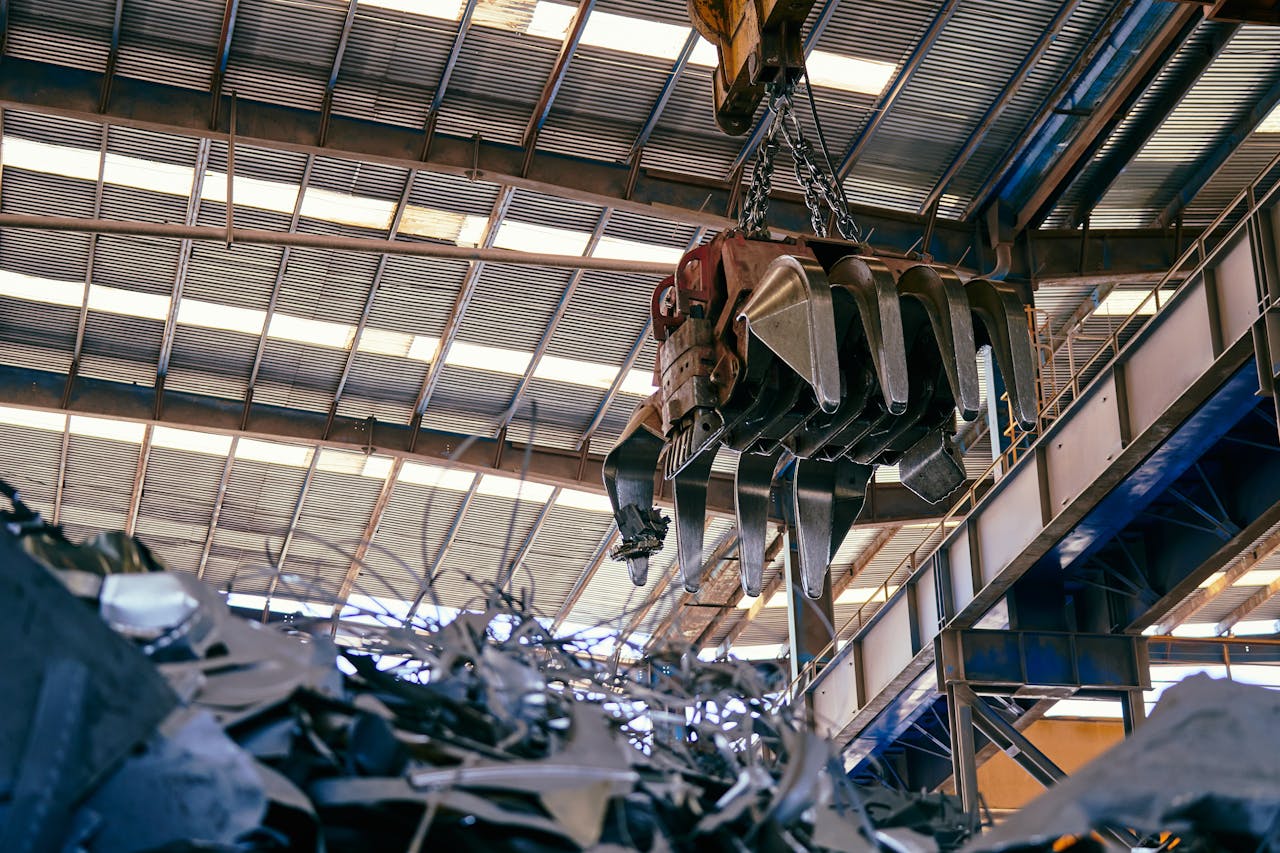 Interior view of a facility with a crane handling metal scrap.